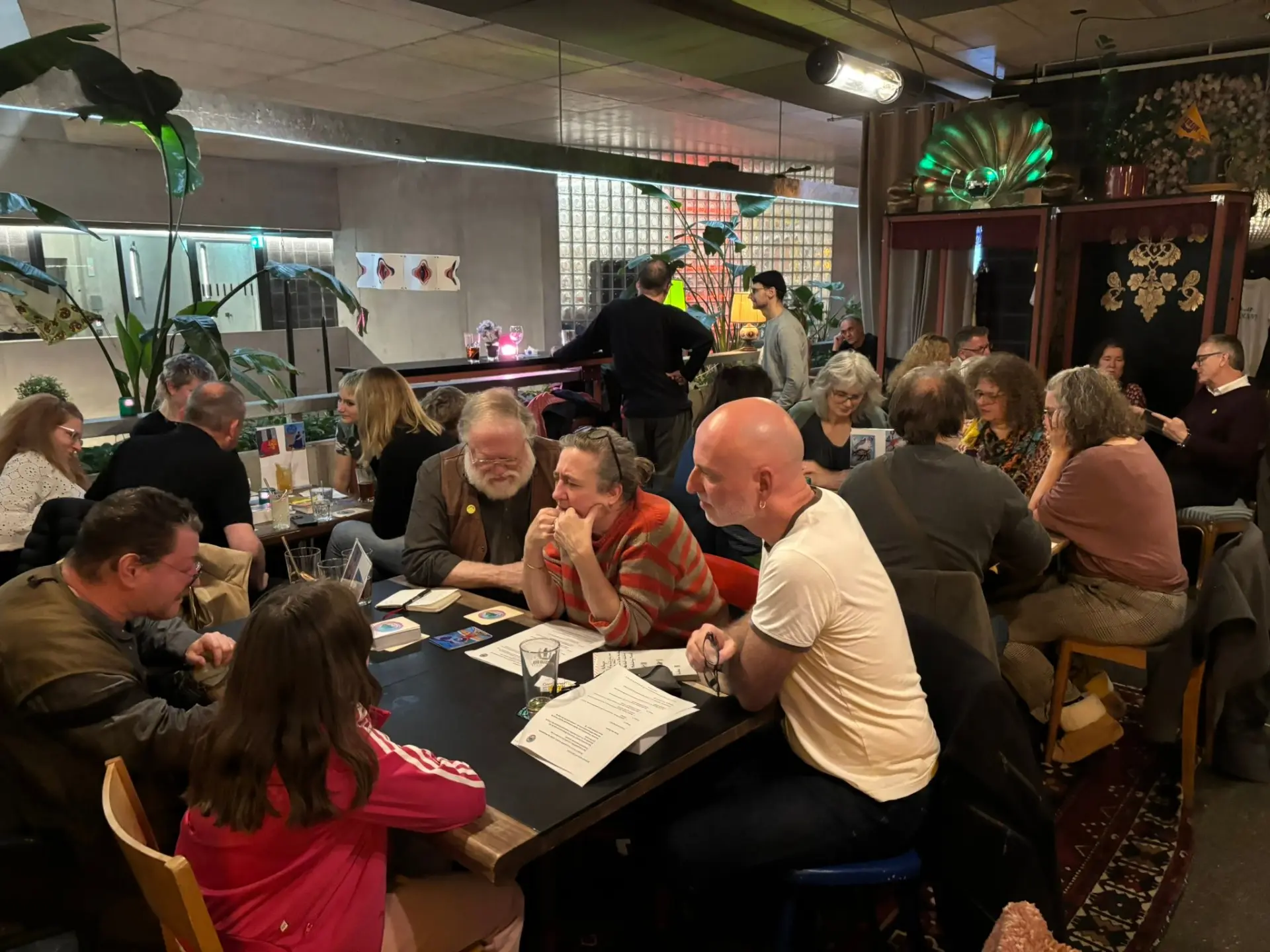 Spielende an Tischen im Kulturhaus während eines STIMULI-Abends